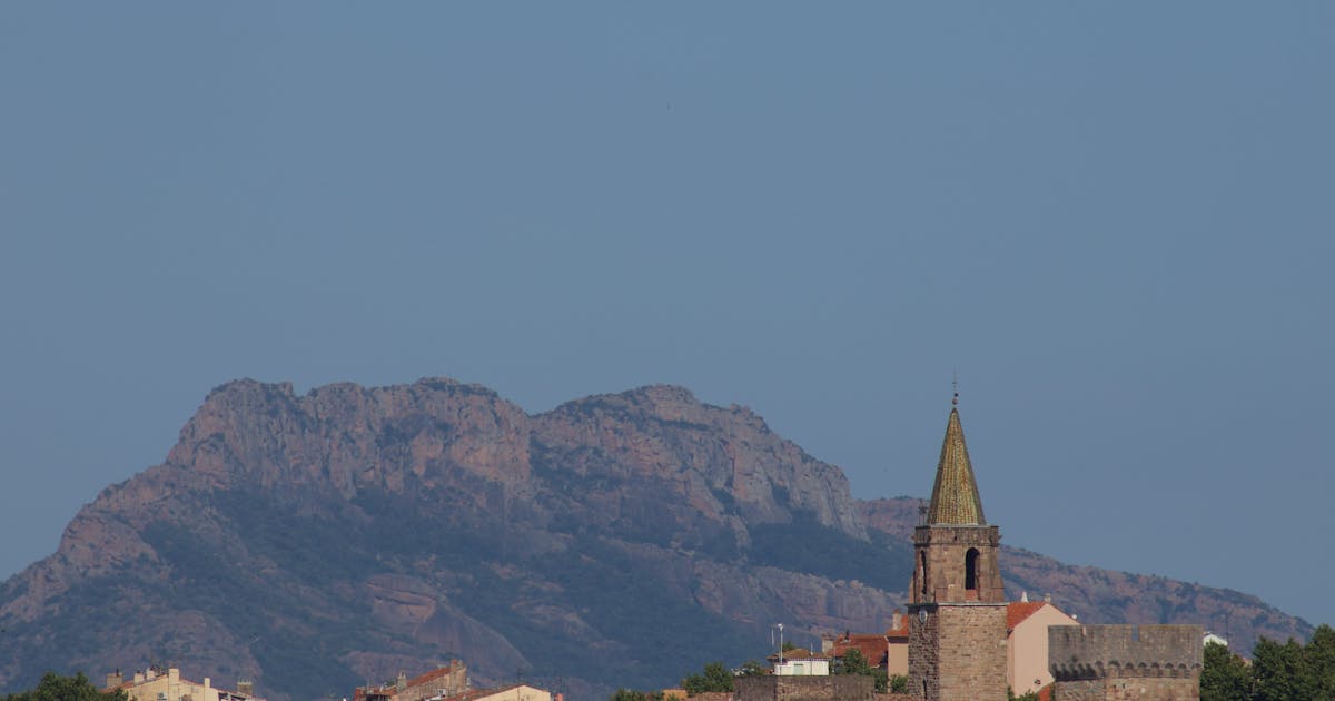 Vue panoramique d'un village perché typique du Luberon sous un ciel bleu éclatant